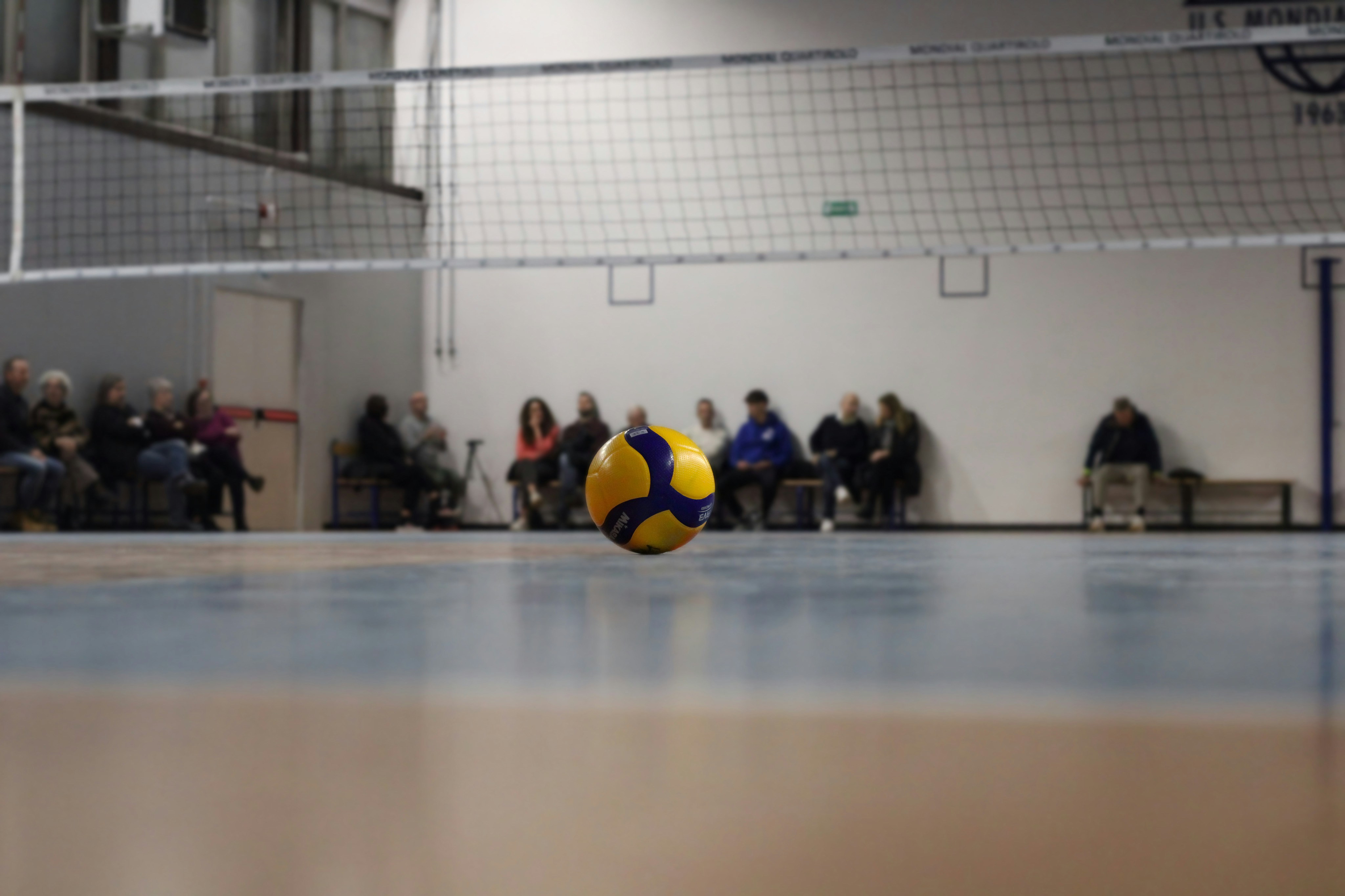 A yellow and blue ball sitting on top of a hard wood floor