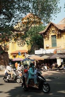 A group of people riding scooters down a street