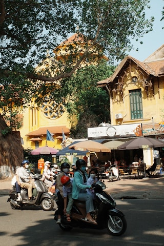 A group of people riding scooters down a street