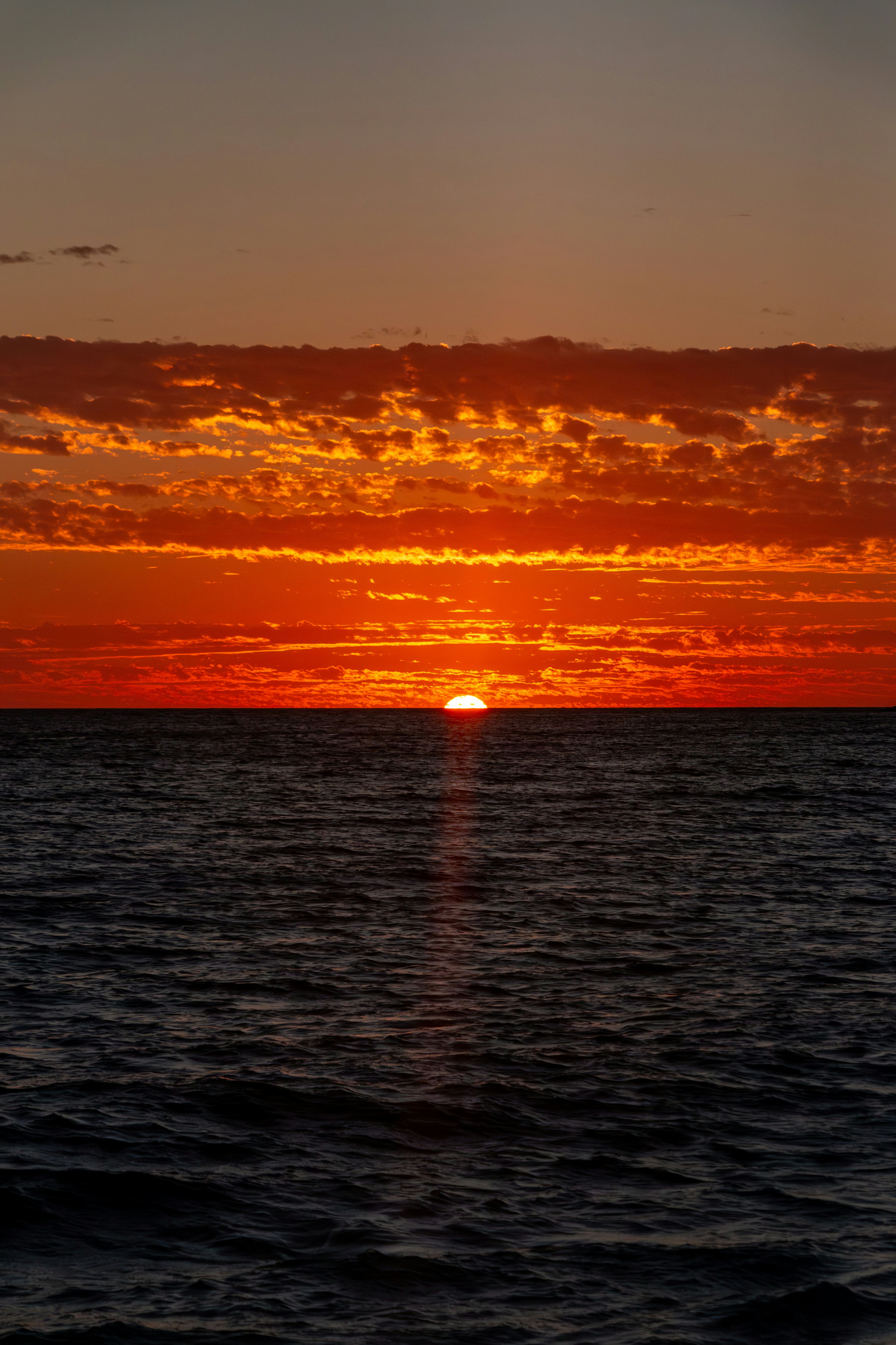 The sun is setting over the ocean on a clear day