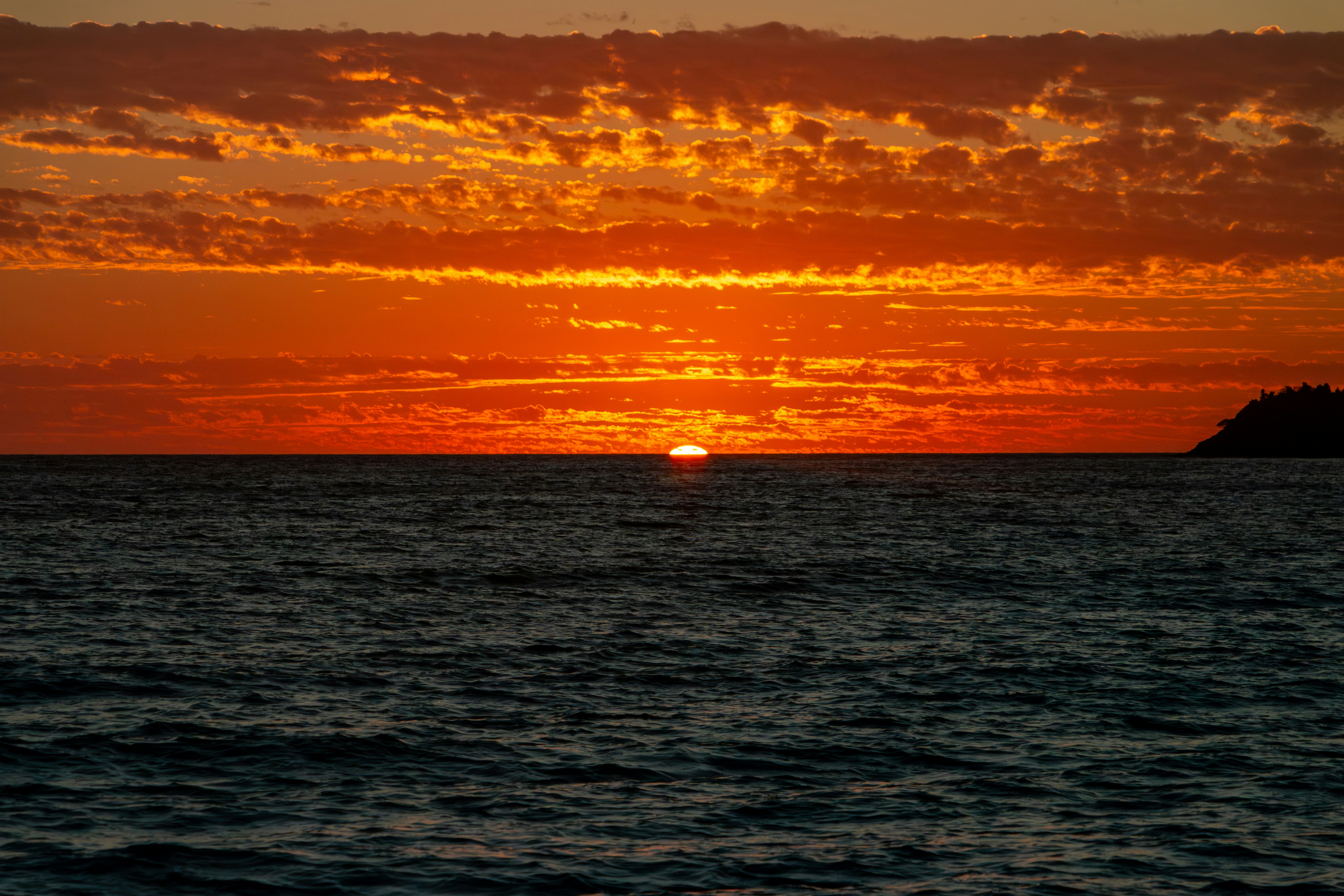 A large body of water with a sunset in the background