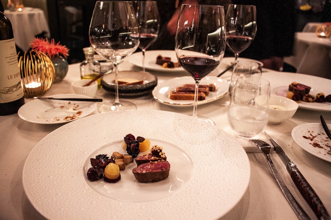 A table is set with wine glasses and plates of food