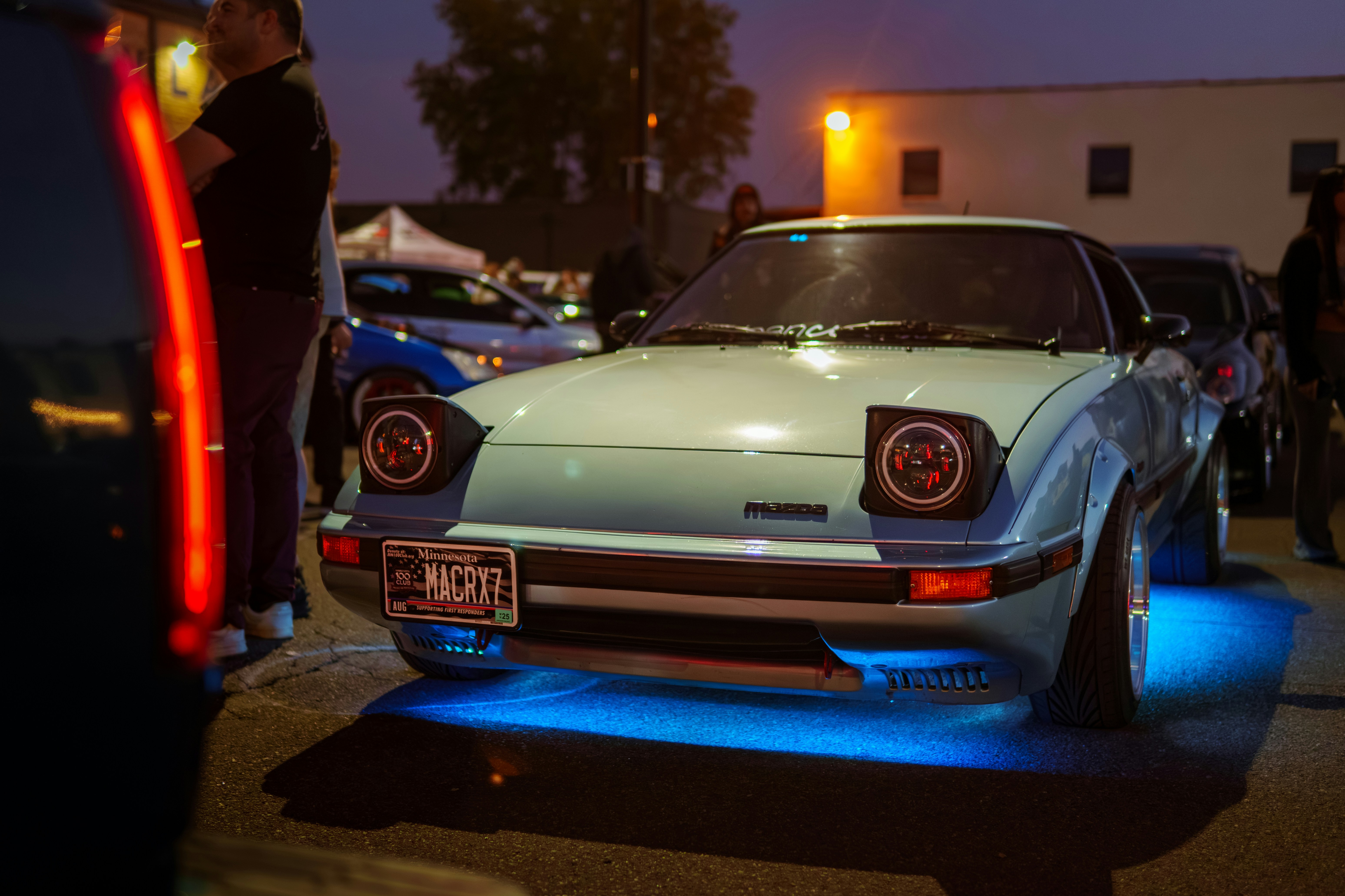 A white car parked in a parking lot next to other cars
