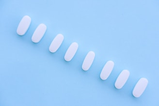 A row of white pills sitting on top of a blue surface