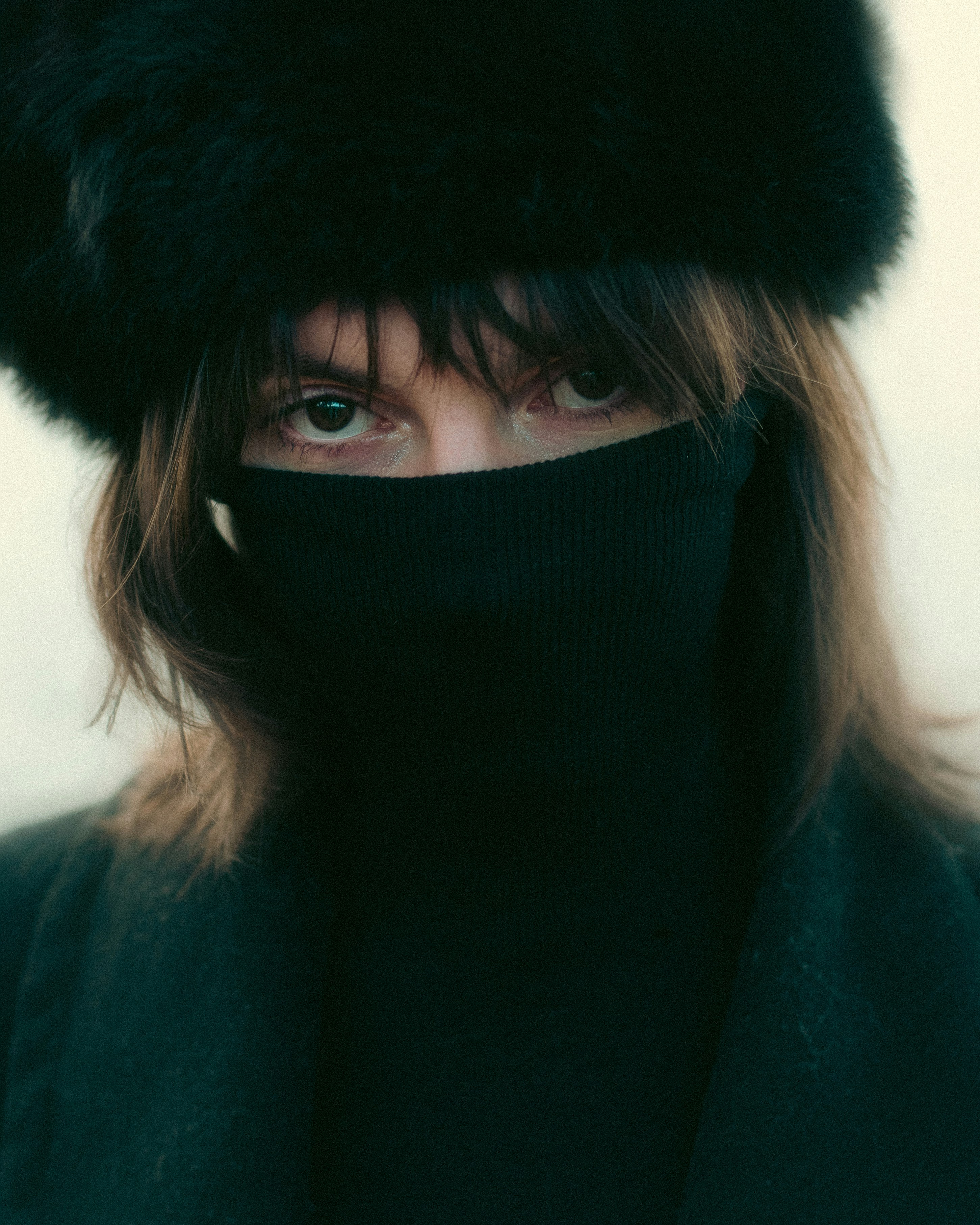 A woman wearing a black hat and scarf