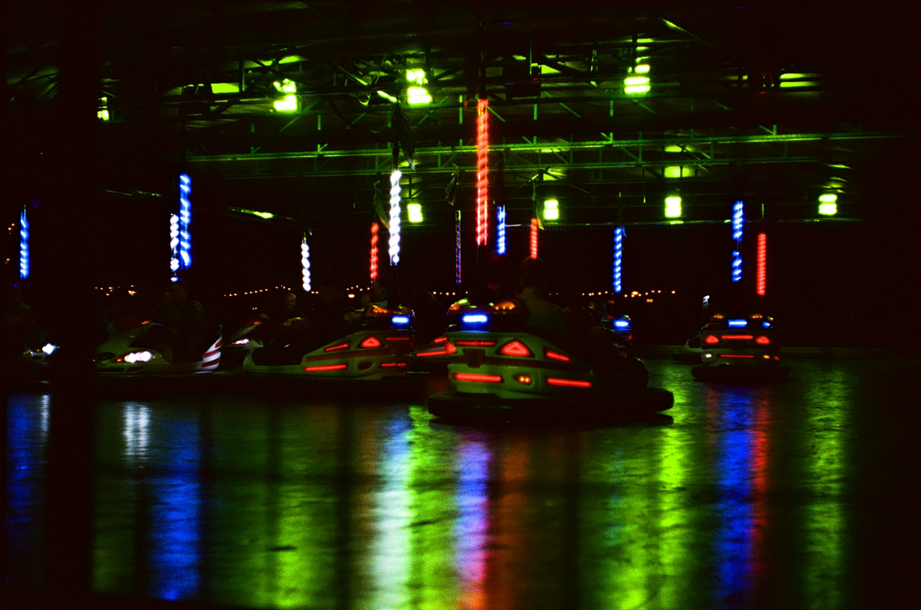 Neon-lit cars in water reflection