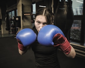 A woman wearing boxing gloves in a gym