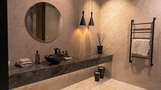 A bathroom with a sink, mirror and towel rack