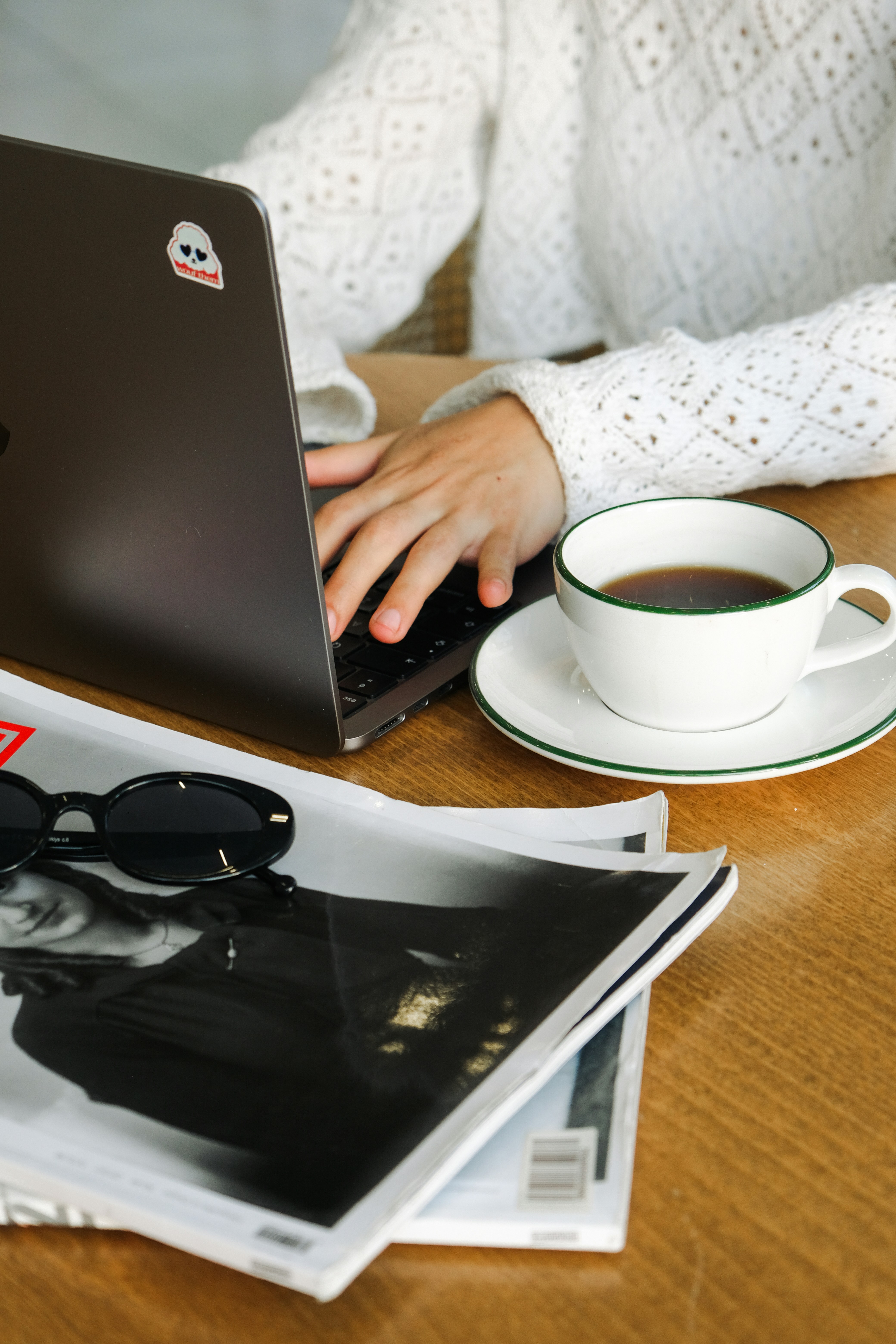 A woman sitting at a table with a laptop computer