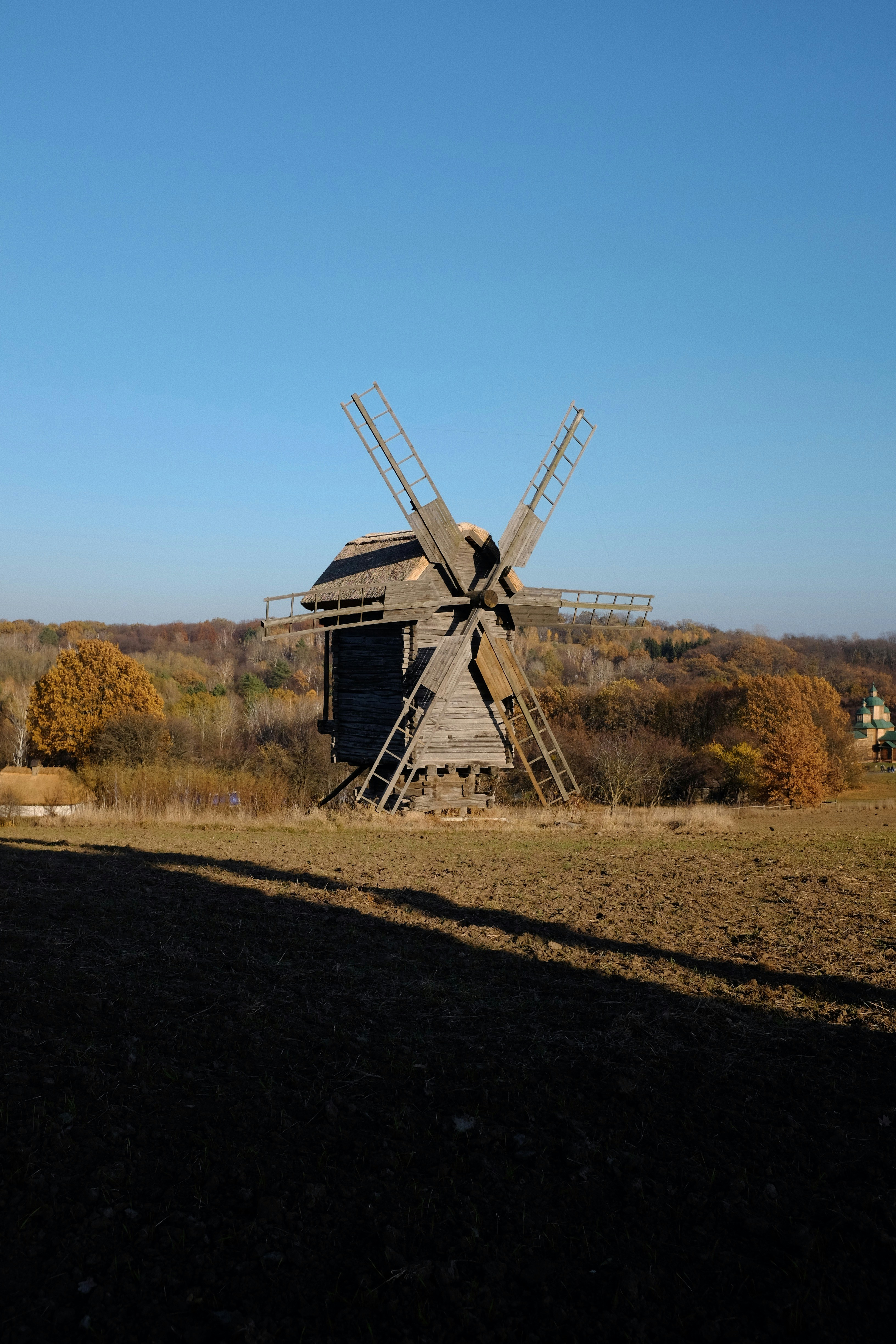 Eine Windmühle auf einem Feld mit Bäumen im Hintergrund