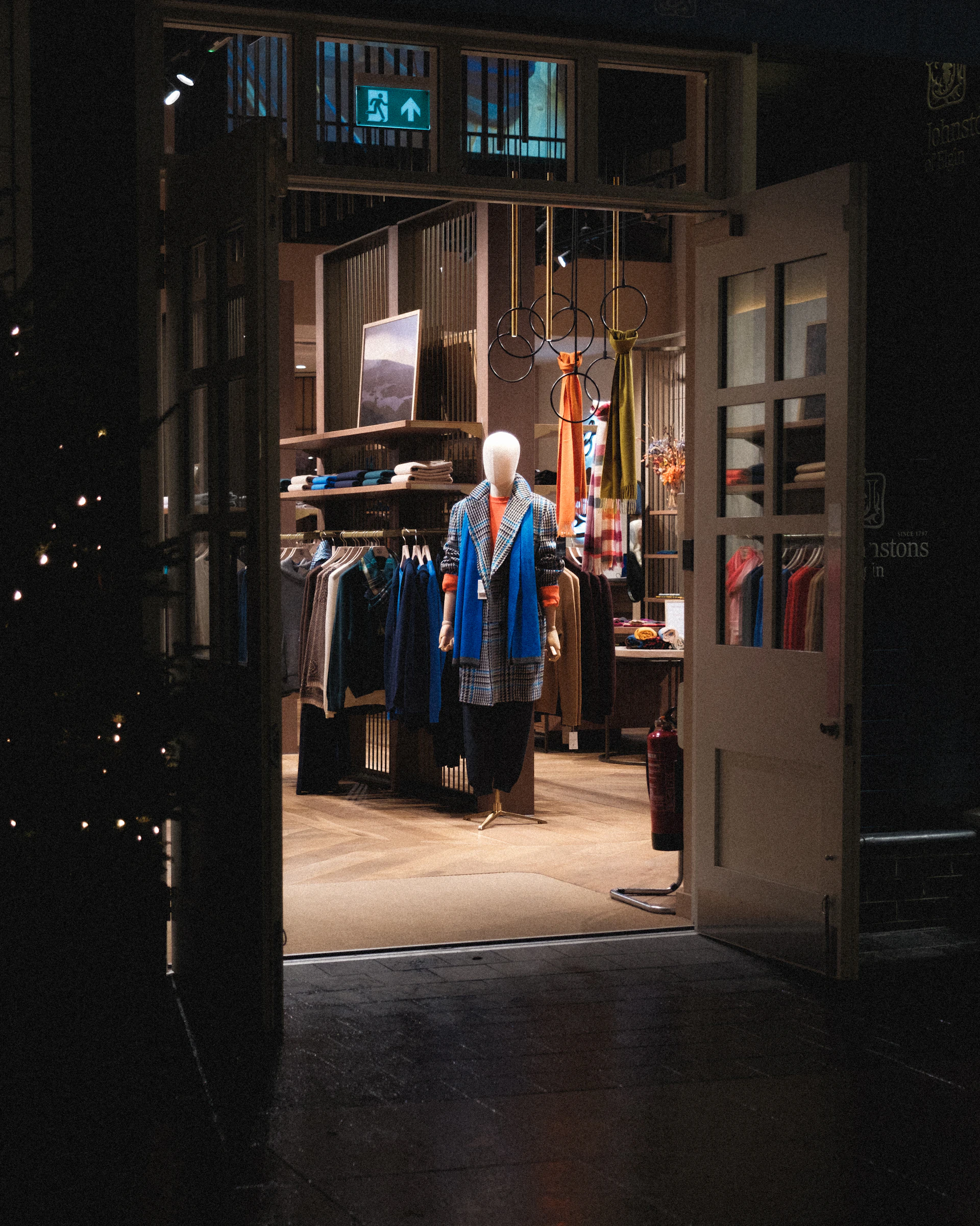 An open door to a clothing store with mannequins