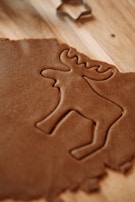 A cookie shaped like a deer on a wooden table