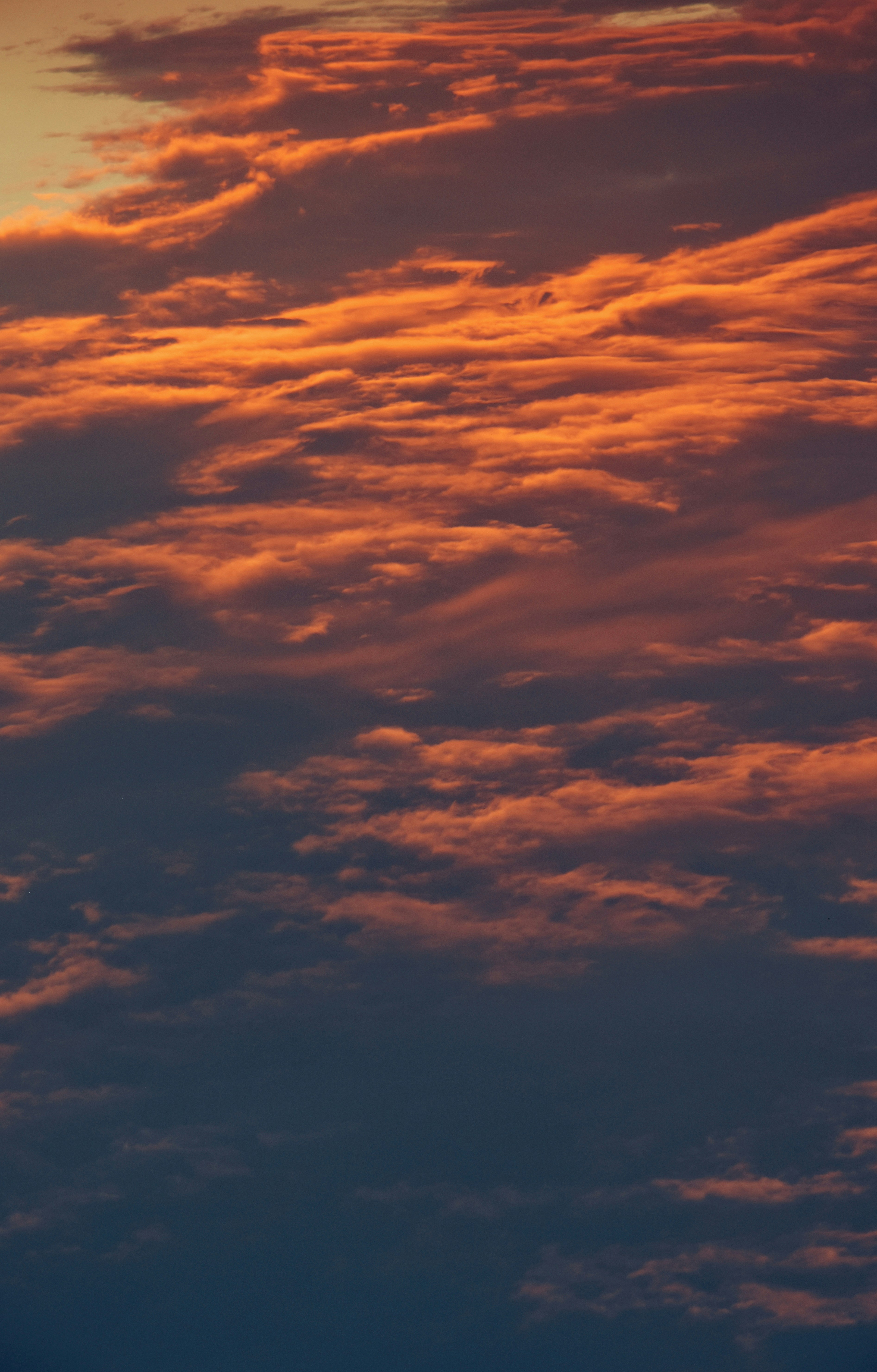 A plane flying in the sky at sunset