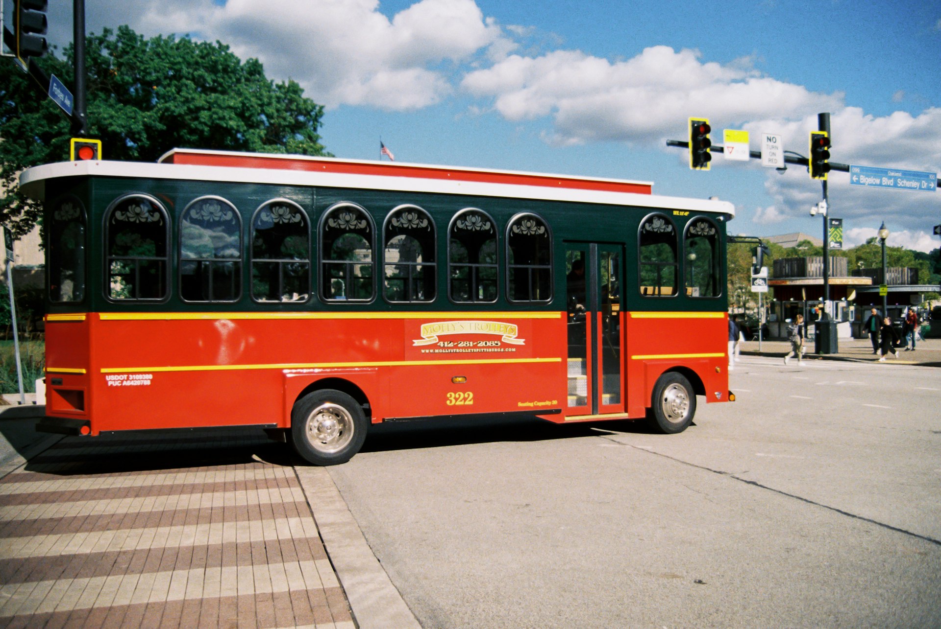 A red and black bus parked on the side of the road