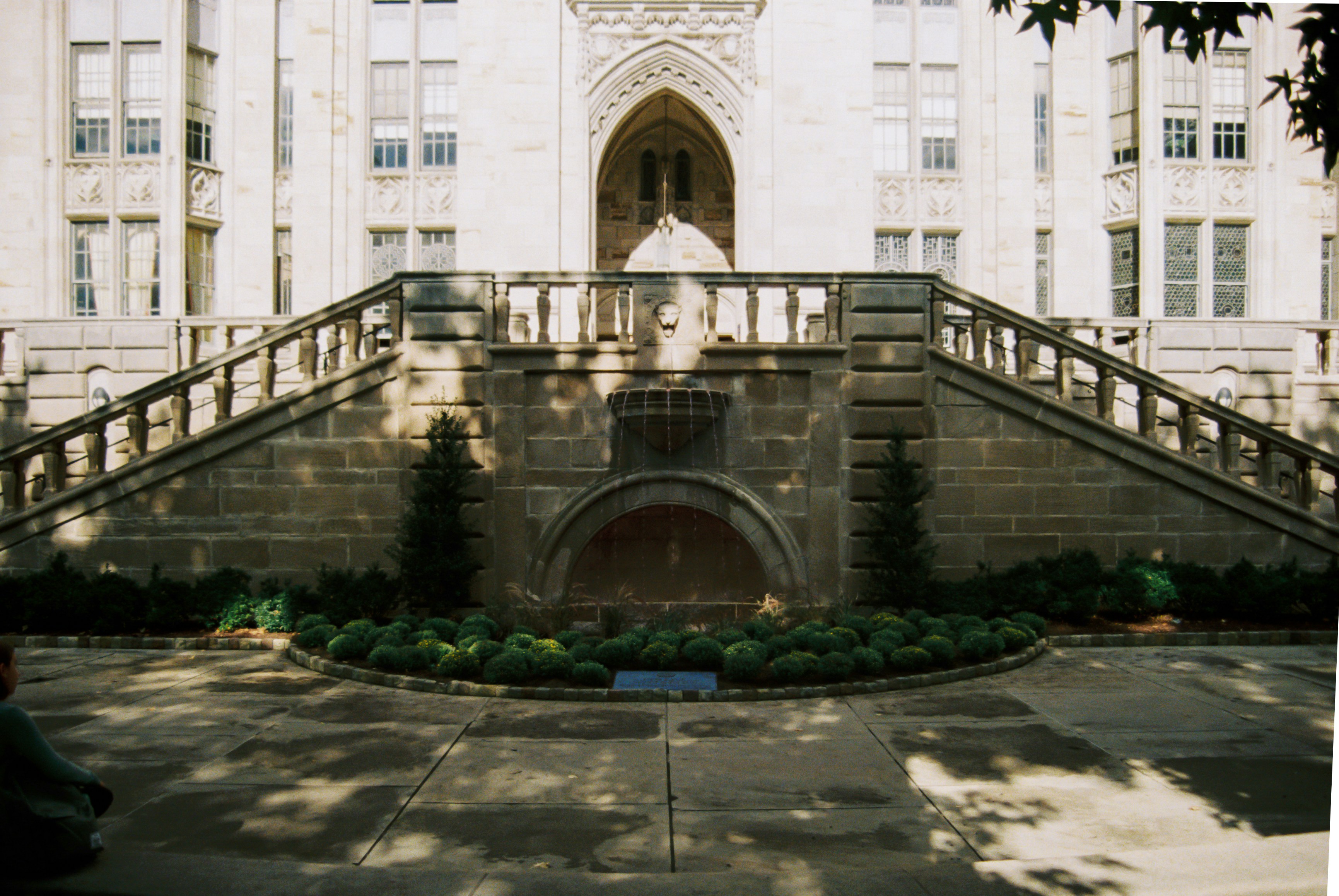 A person sitting on a bench in front of a building, Shot by Canon A1 with Kodak UltraMax 400