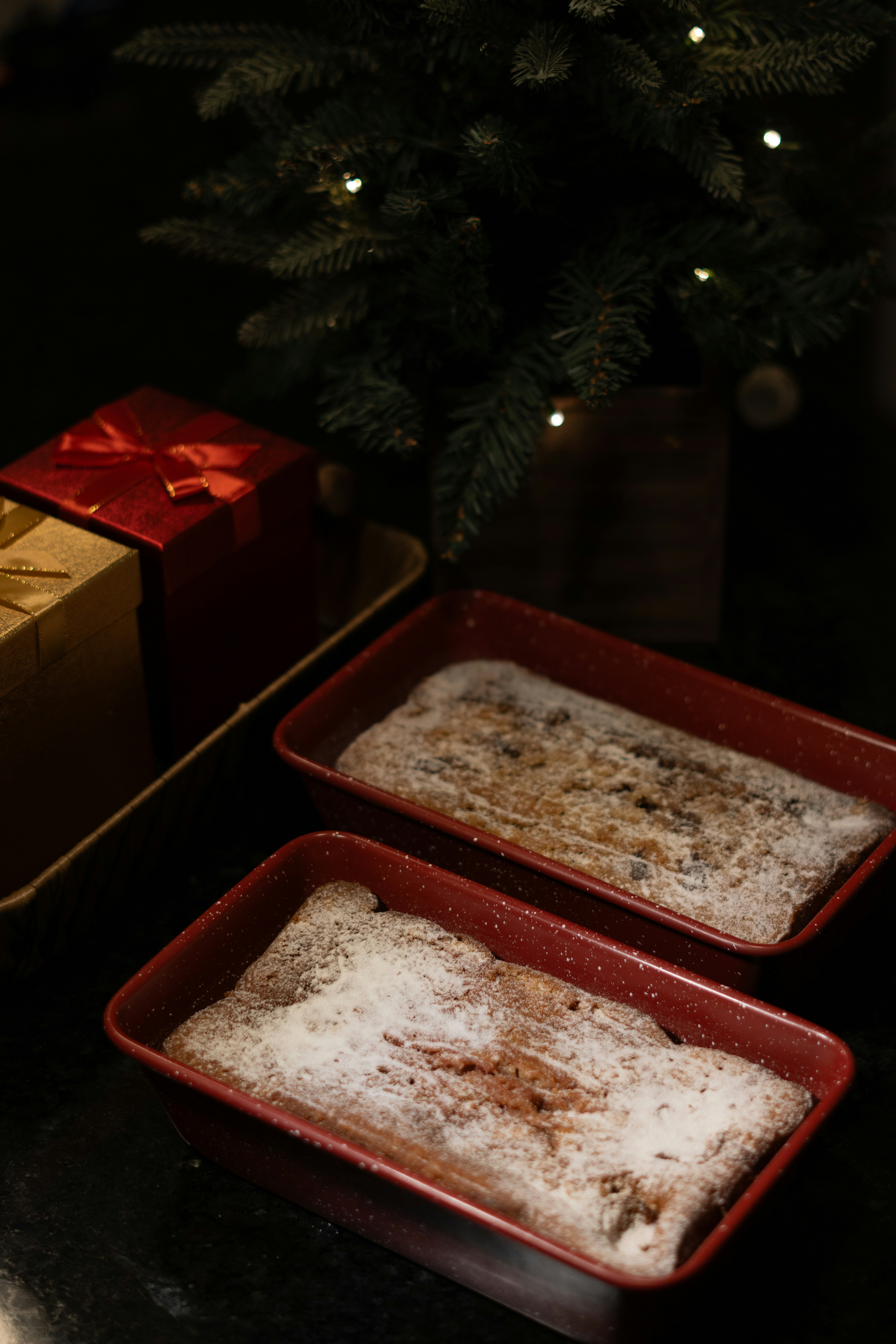 A couple of pans filled with food next to a christmas tree