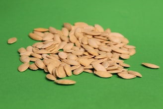 A pile of sunflower seeds on a green background