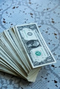 A stack of twenty dollar bills sitting on top of a table