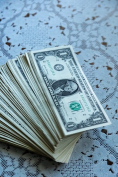 A stack of twenty dollar bills sitting on top of a table