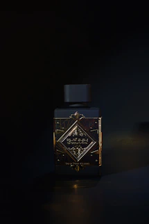 A bottle of perfume sitting on a table in the dark
