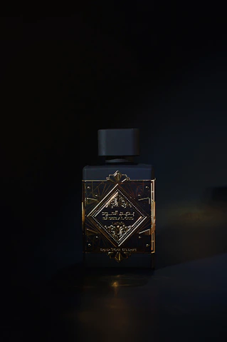 A bottle of perfume sitting on a table in the dark