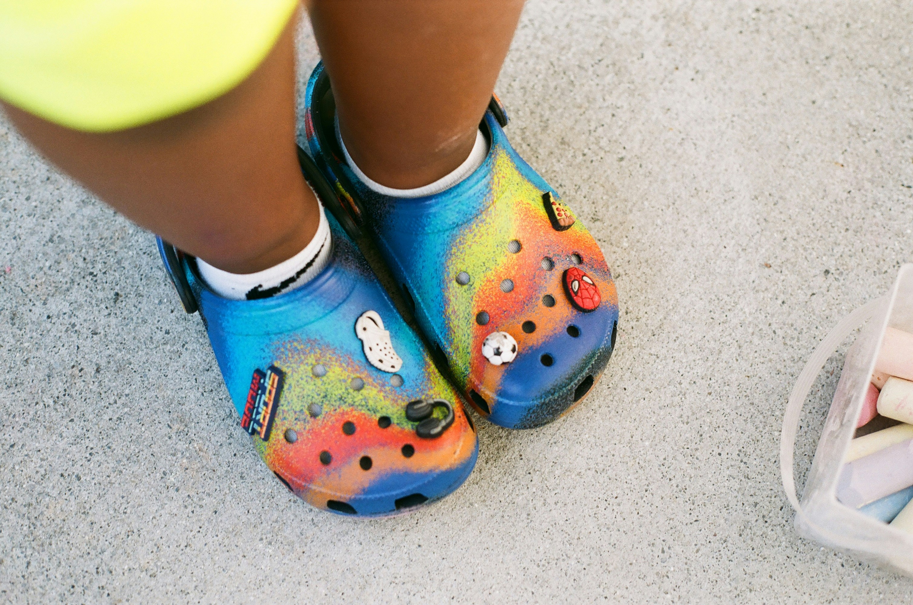 A close up of a child's feet wearing colorful shoes