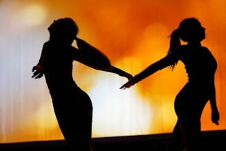 A couple of people that are dancing in the dark