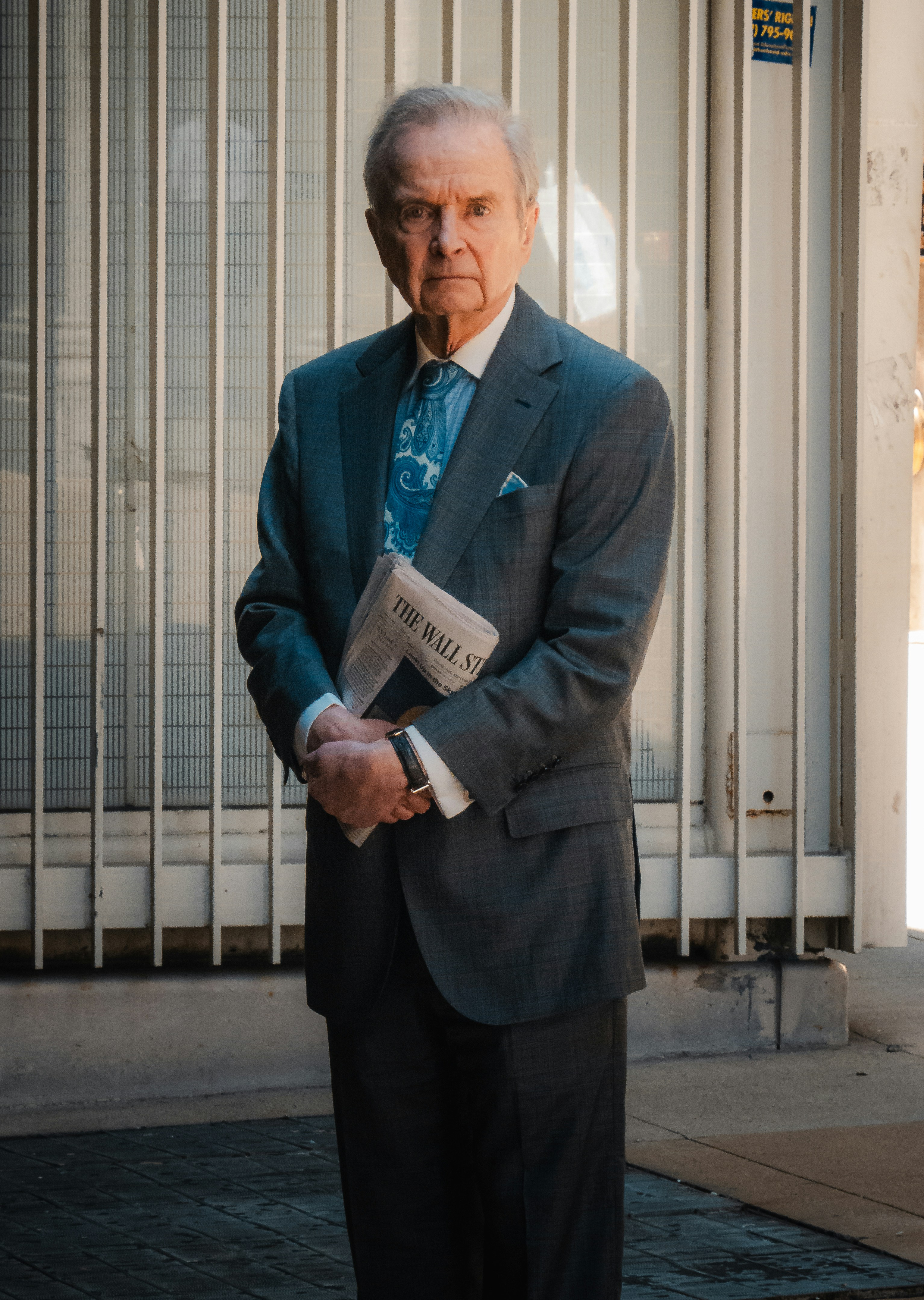 A man in a suit and tie standing in front of a building photo – Free ...