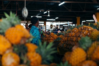 A woman looking at pineapples in a store