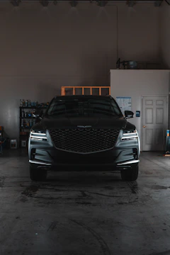 A car parked inside of a garage next to another car