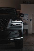 A black car parked in a garage next to a white door