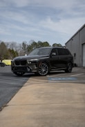 A black BMW suv parked in a parking lot