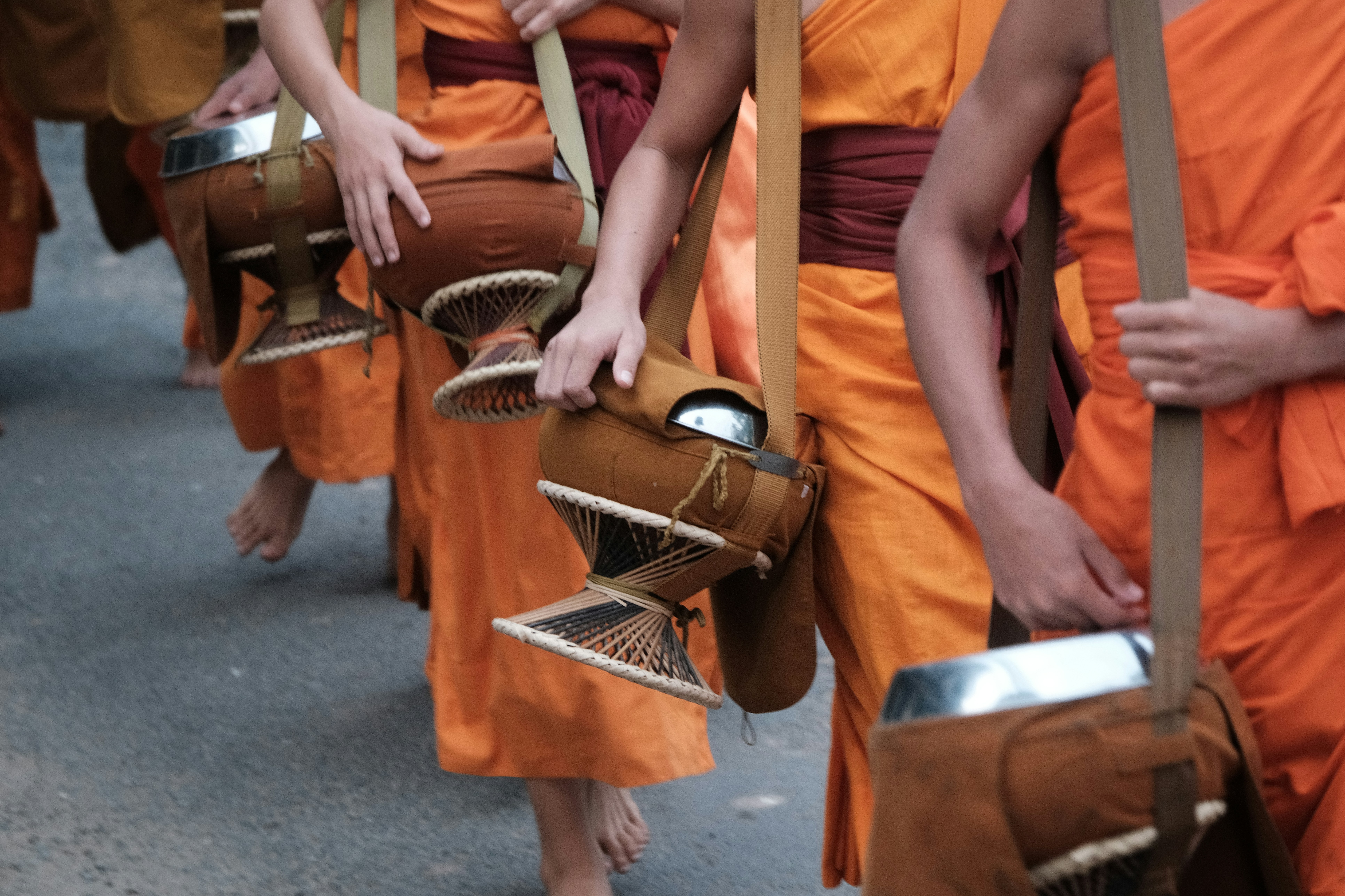 A group of Buddhist monks walk along a street in Luang Prabang as part of the customary alms giving ceremony