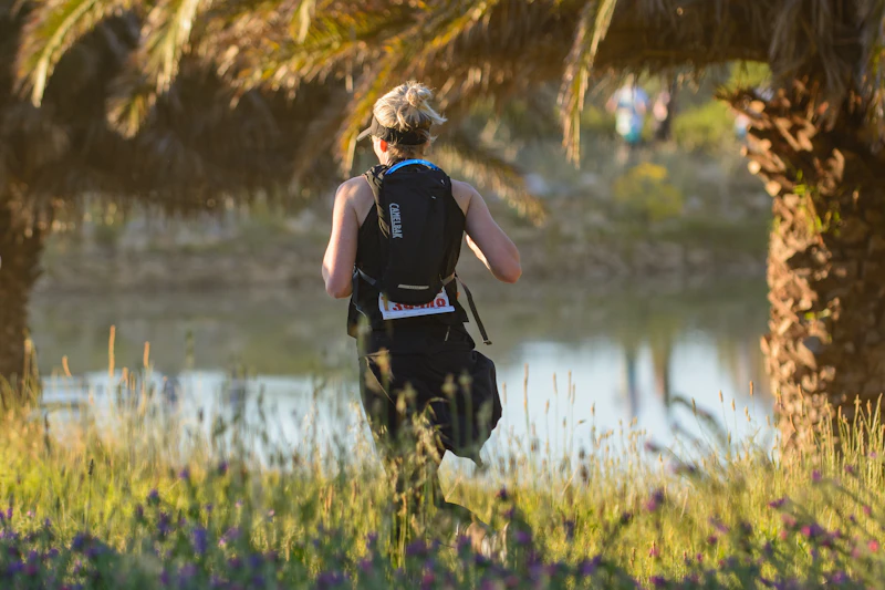 Femme traileuse courant avec gilet d'hydratation