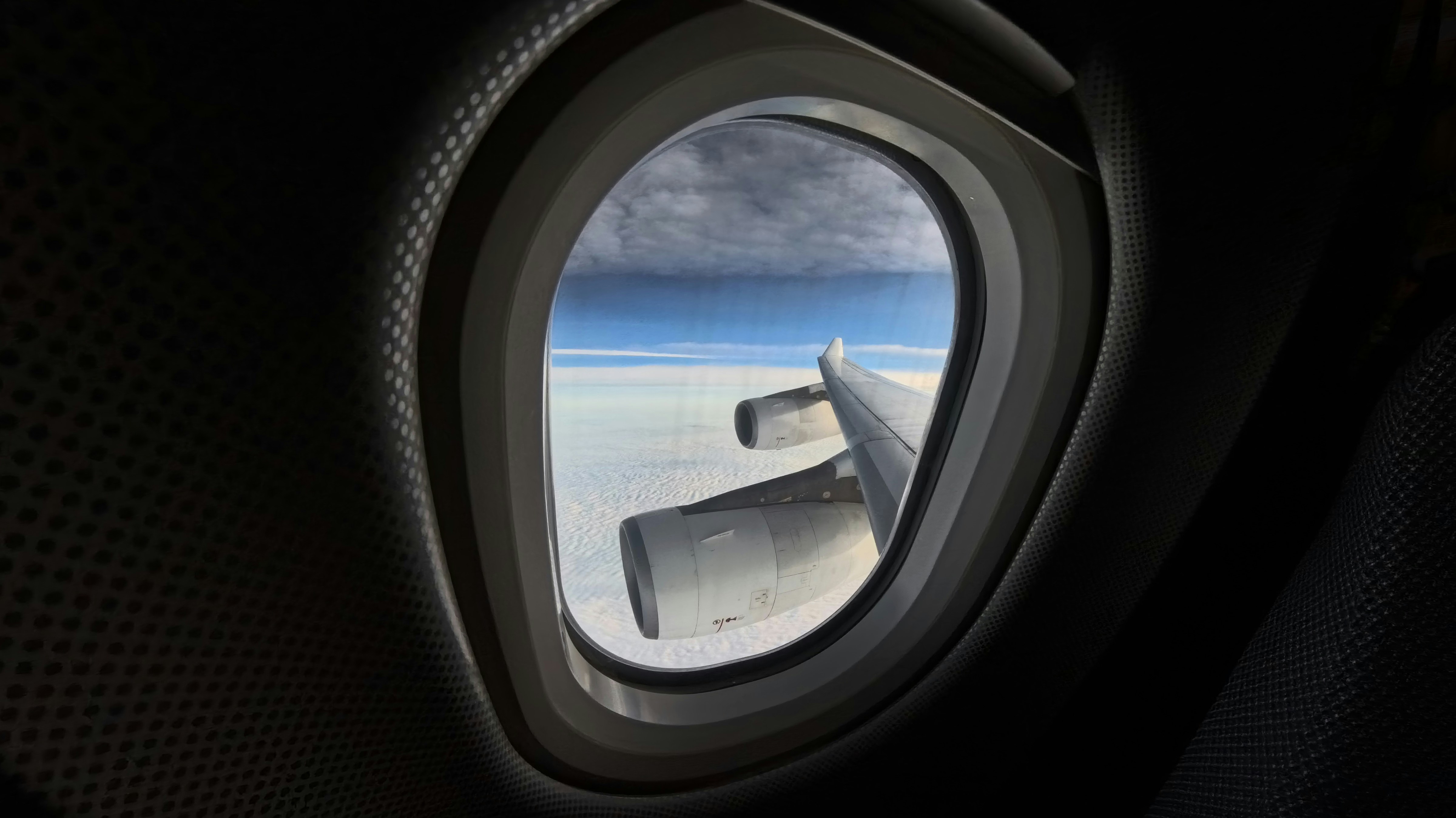 A view of the wing of an airplane through a window, Wide angle shot of an airplane window
