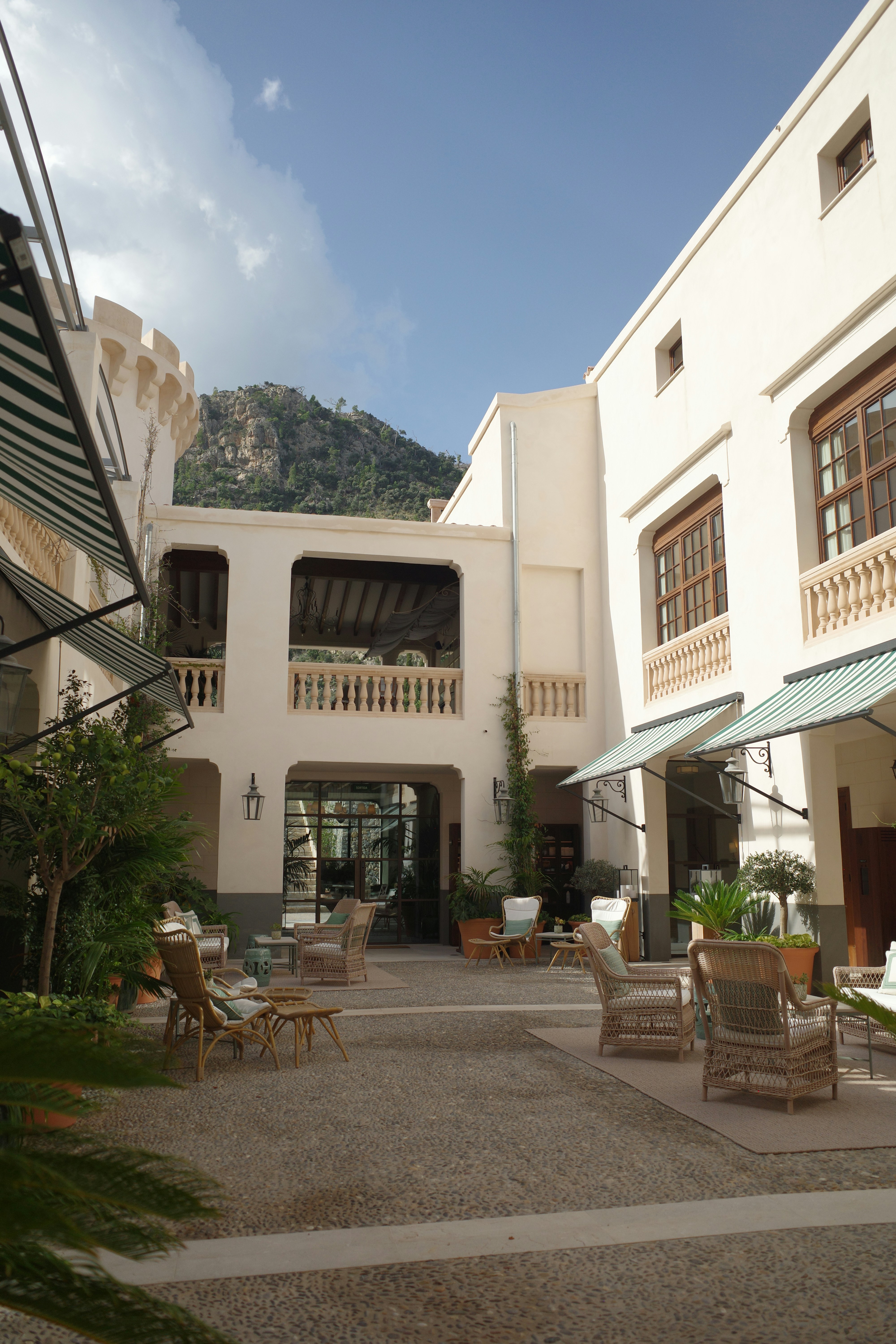 A courtyard with chairs and umbrellas in front of a building