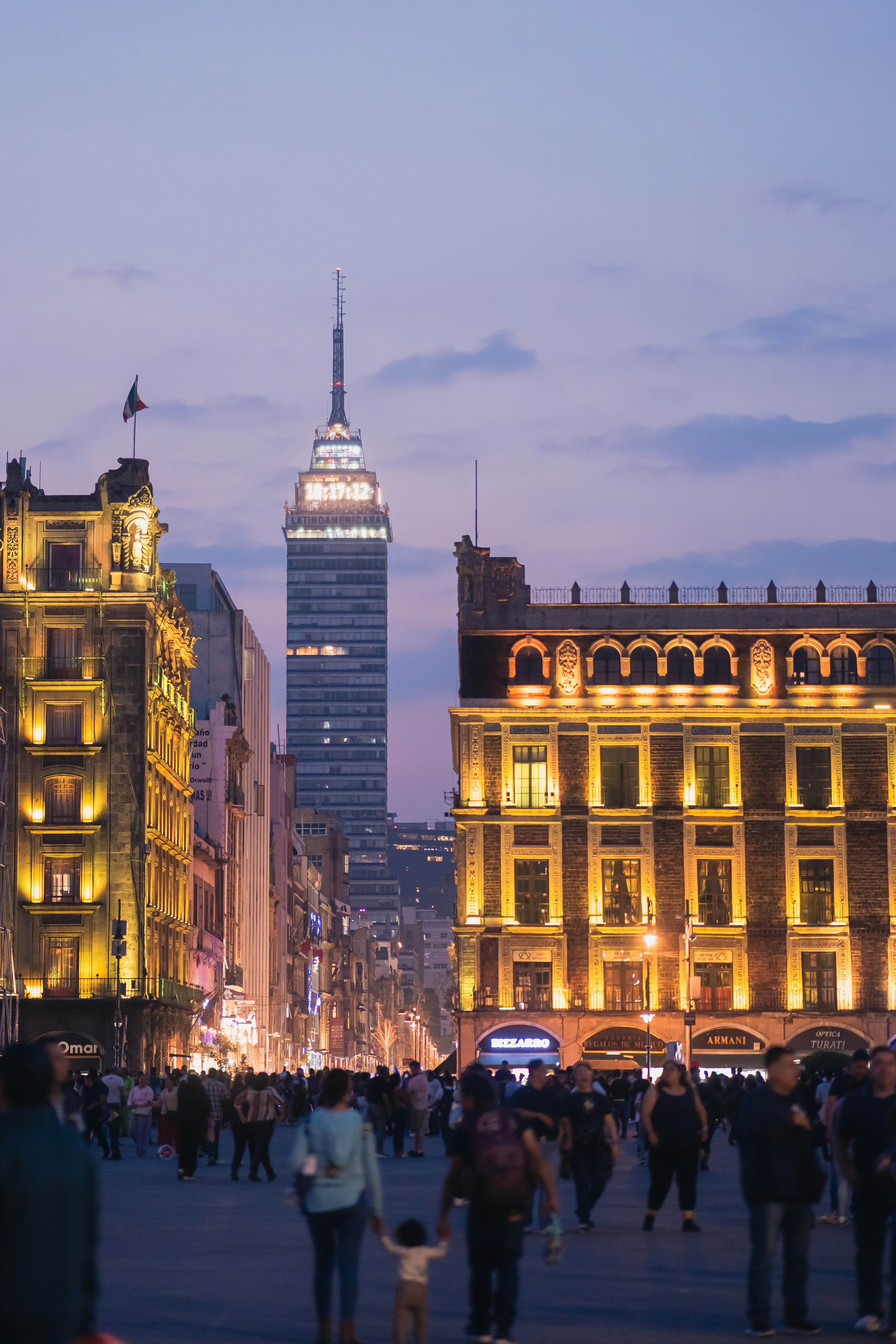Vibrant city destination at dusk with illuminated skyline, street activity, and warm ambient urban lighting