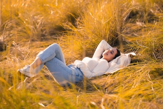 A woman laying in a field of tall grass