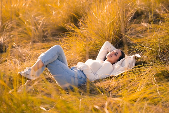 A woman laying in a field of tall grass