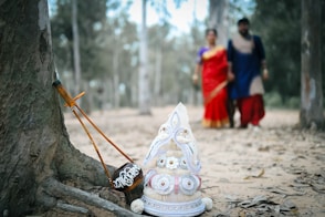 Two people walking in the woods with a small tree