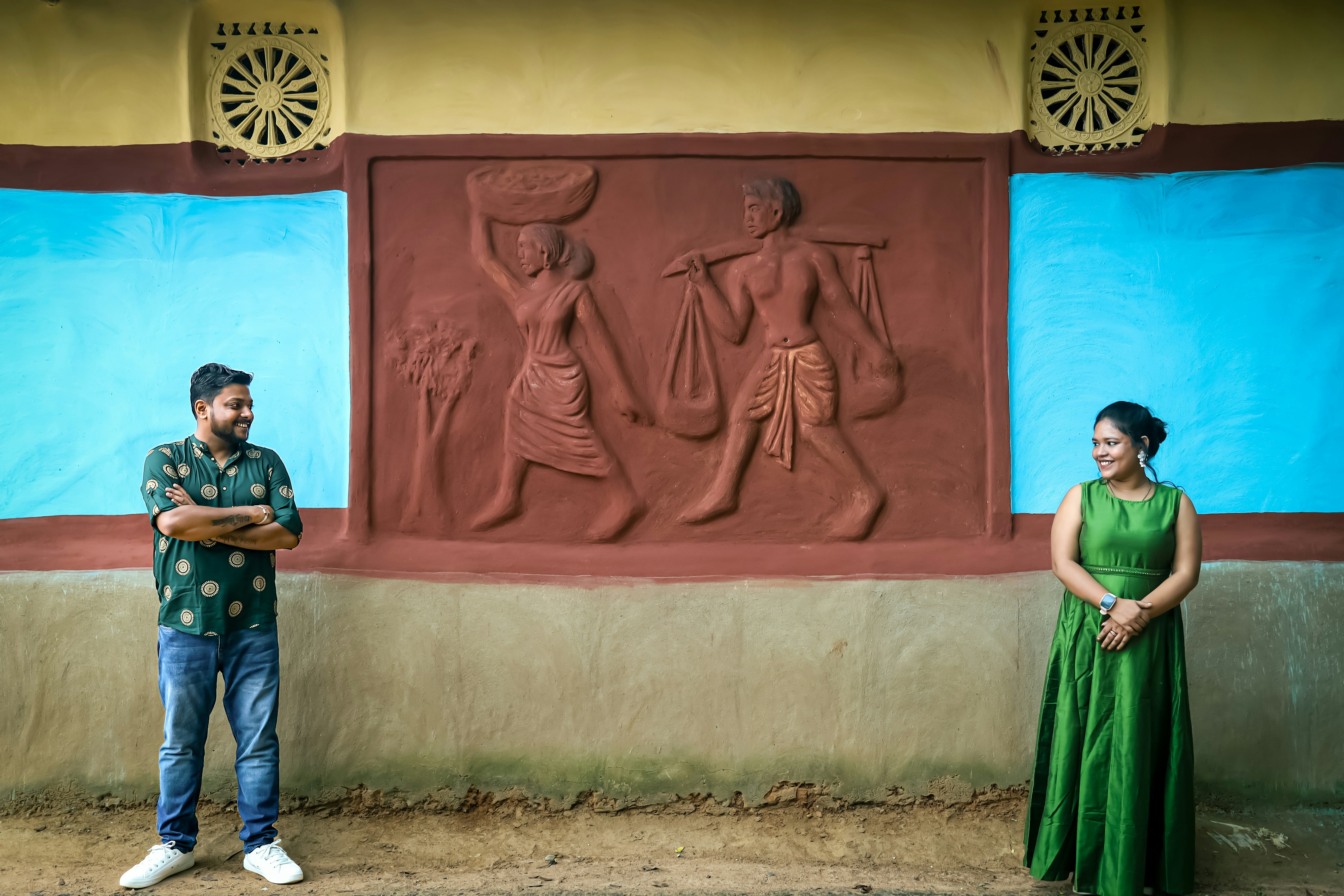 A man and a woman standing in front of a wall