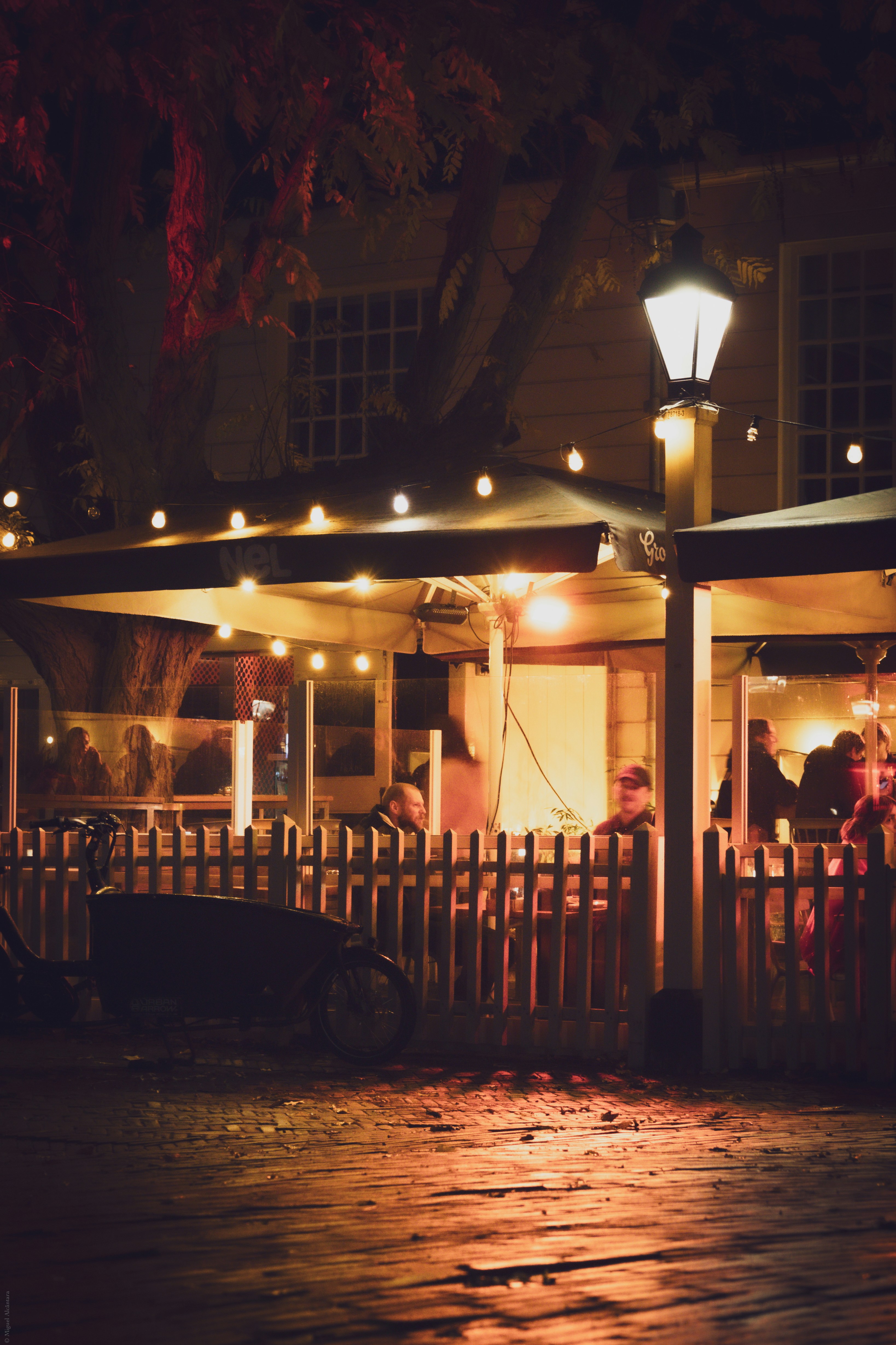 A group of people standing outside of a house at night