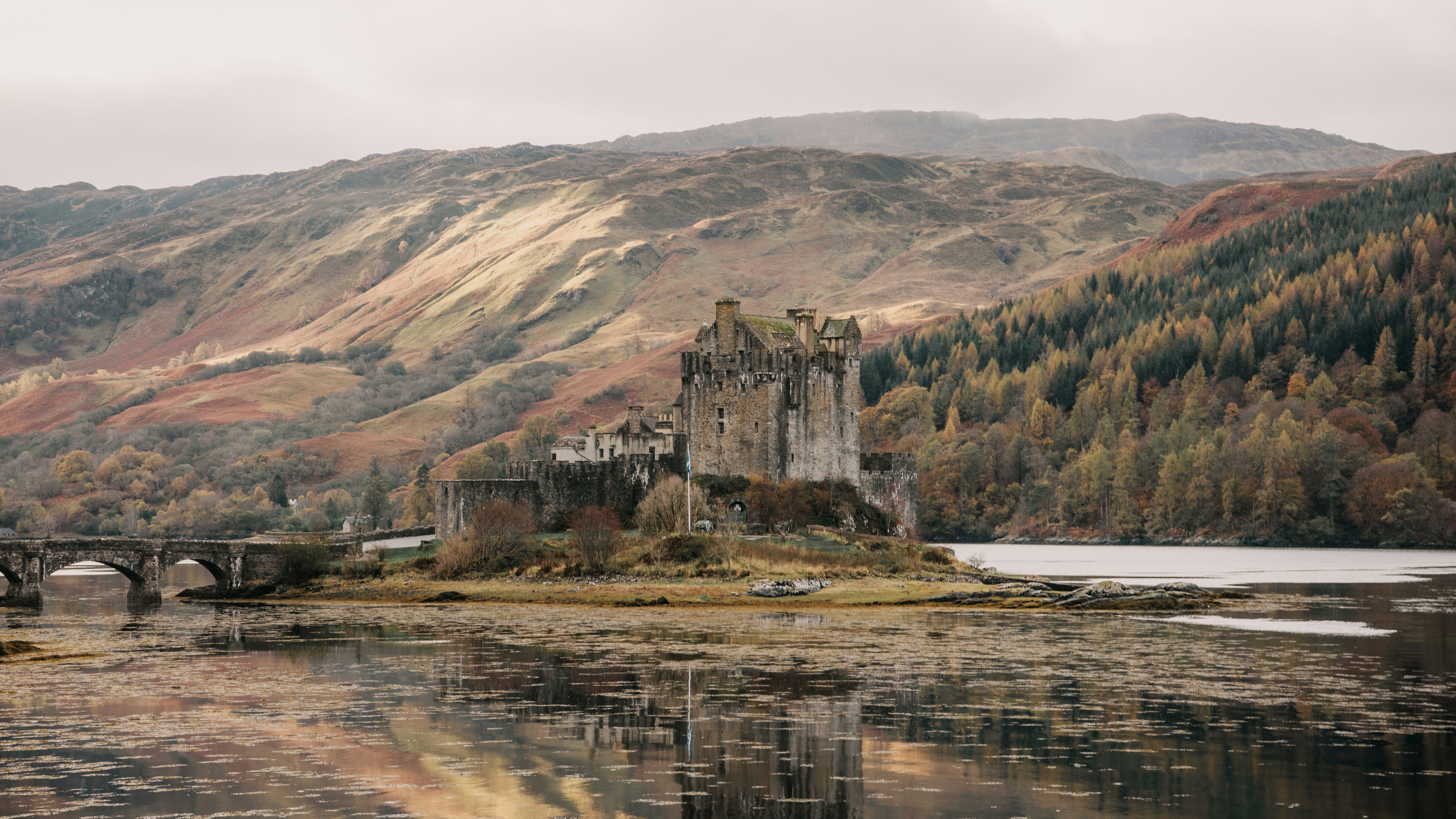 A castle sits on a small island in the middle of a lake