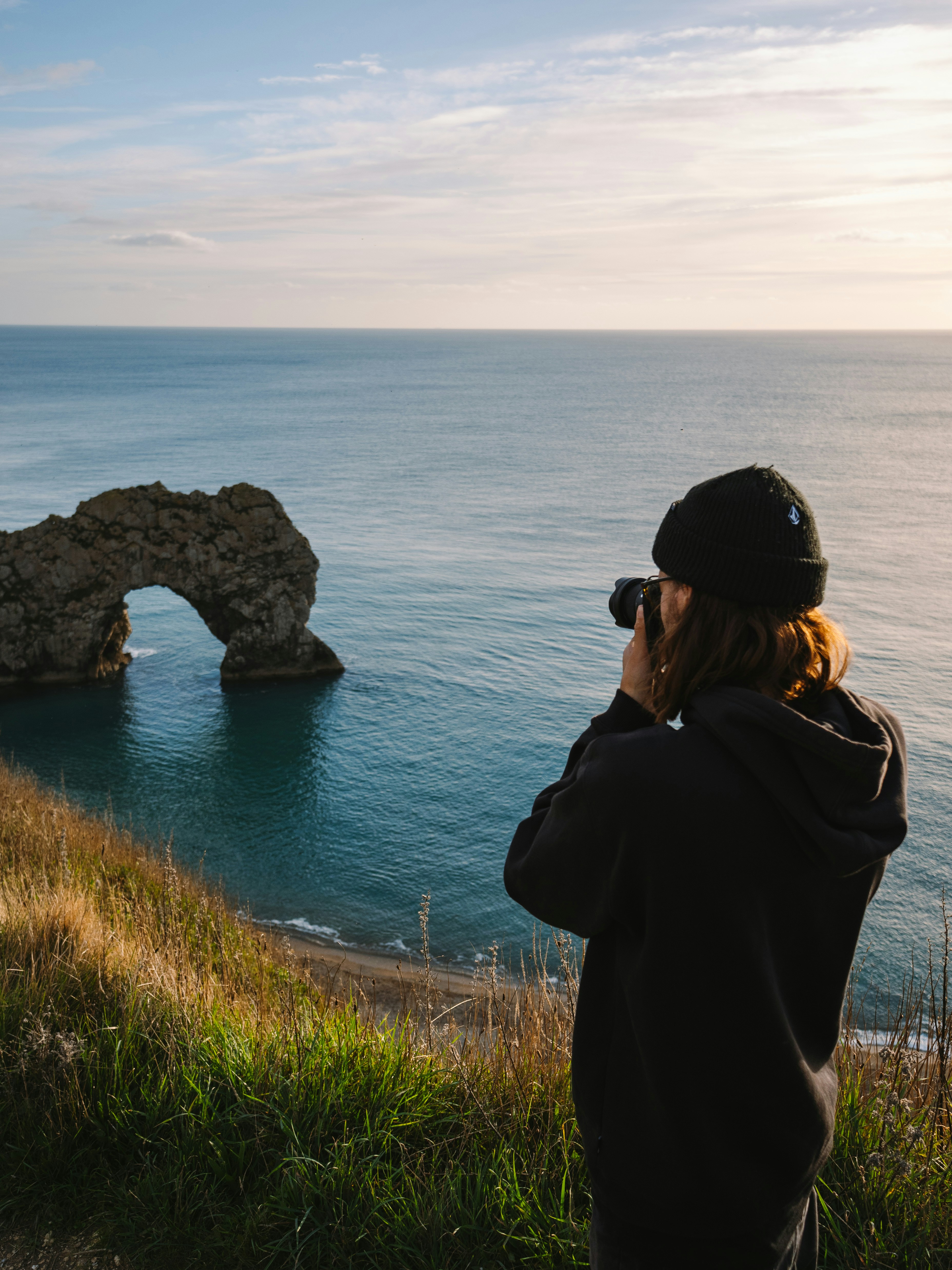 A person taking a picture of the ocean with a camera
