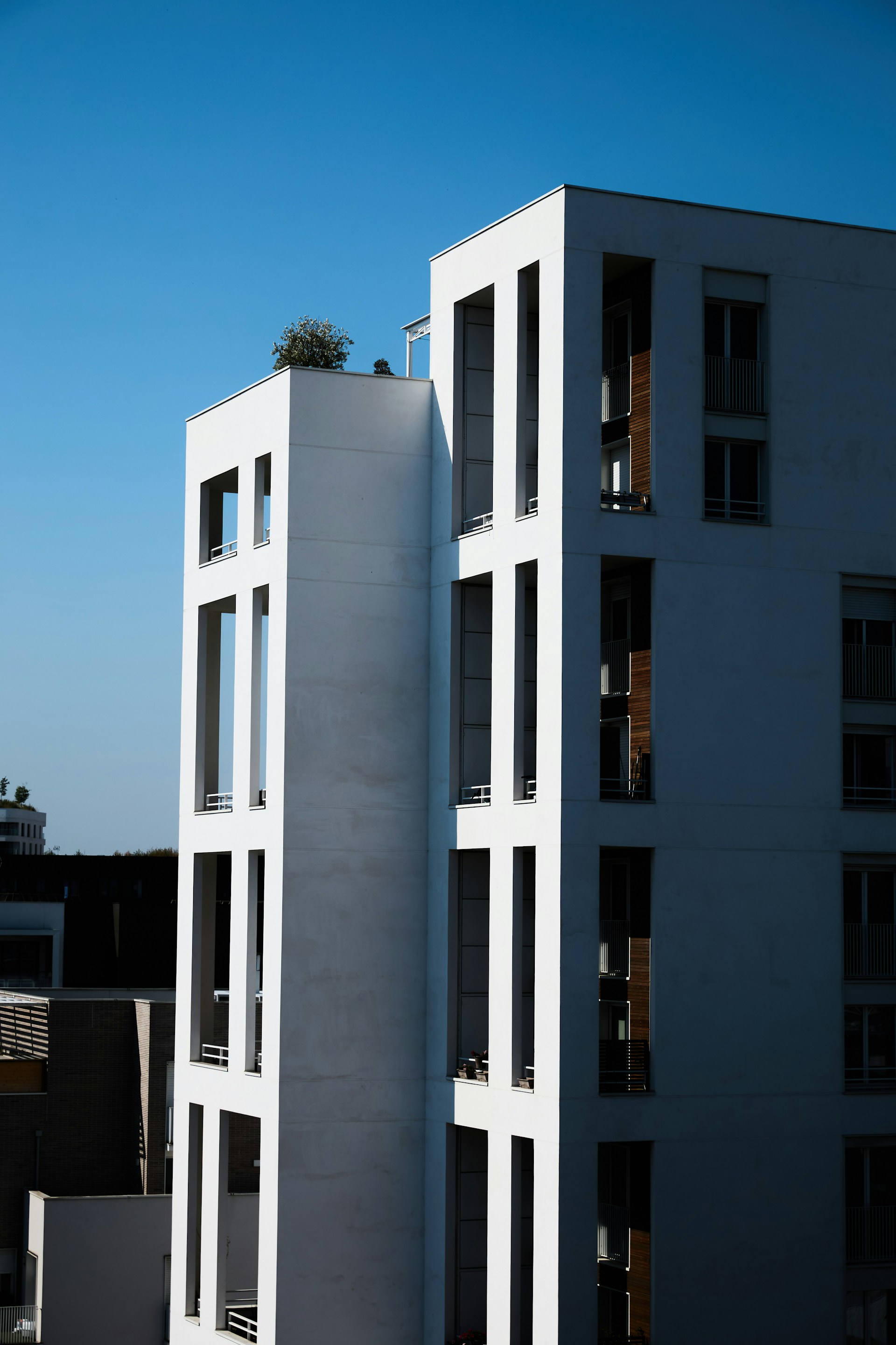 A tall white building with balconies on top of it