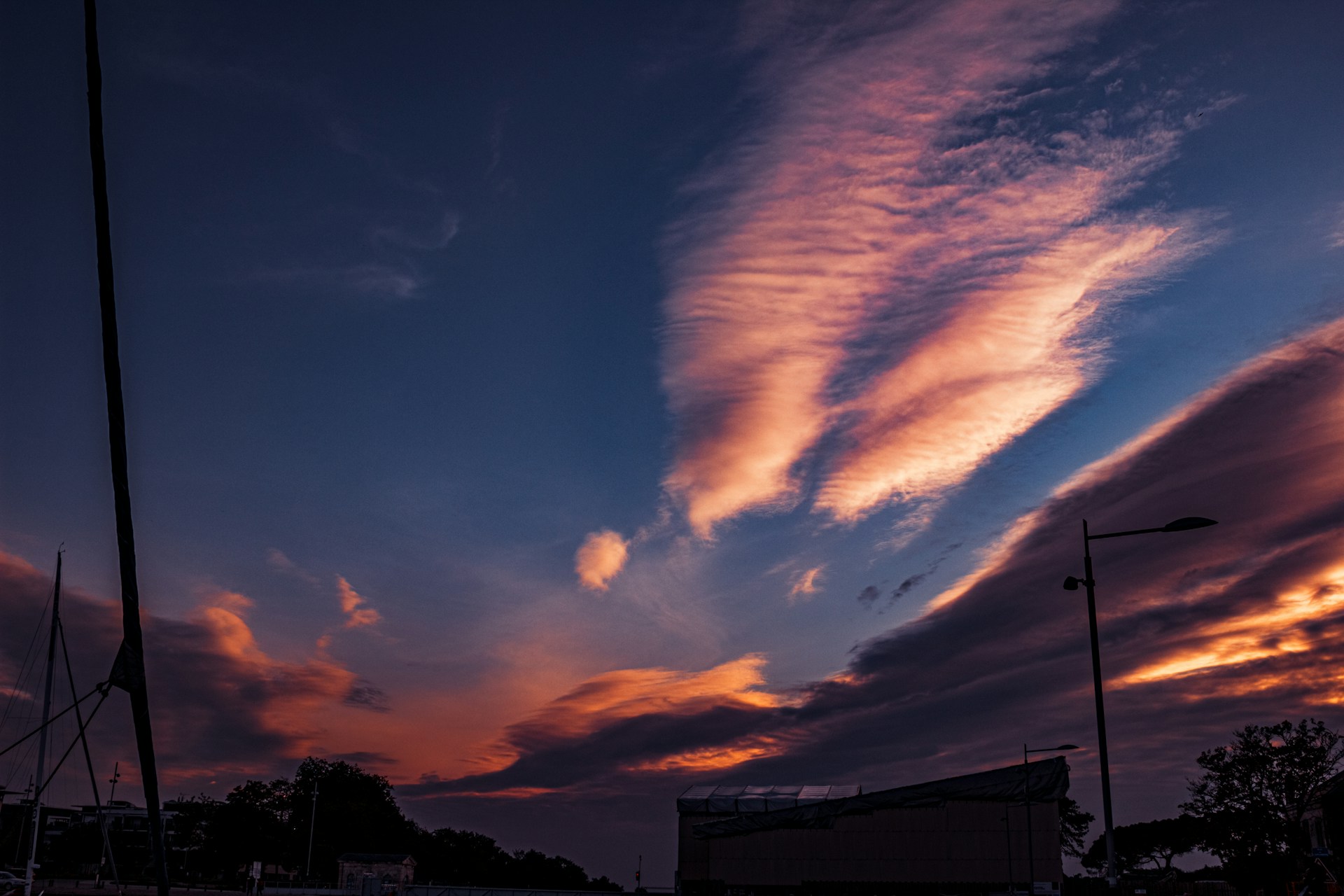 A sunset with clouds in the sky and a building in the background
