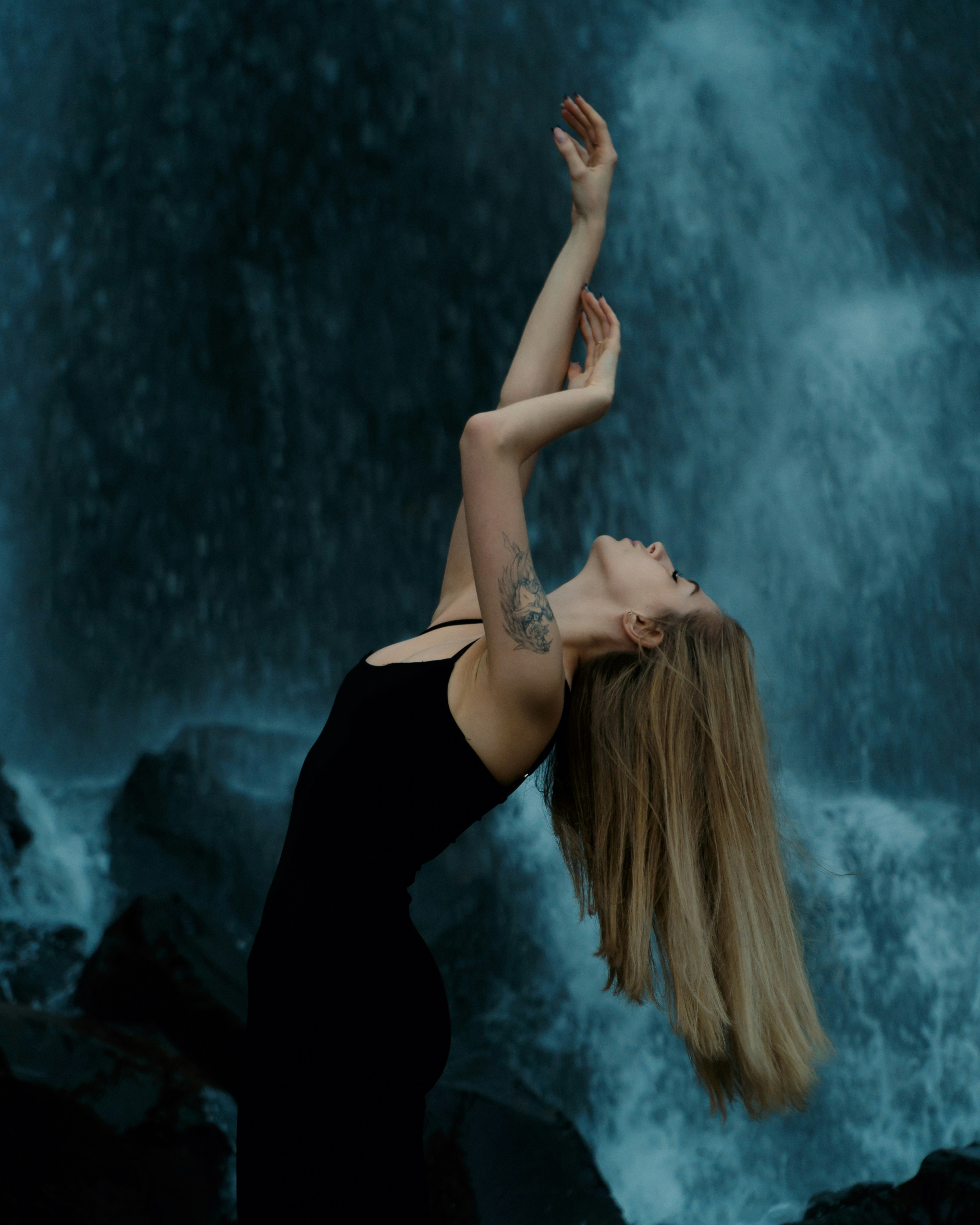 A woman standing in front of a waterfall