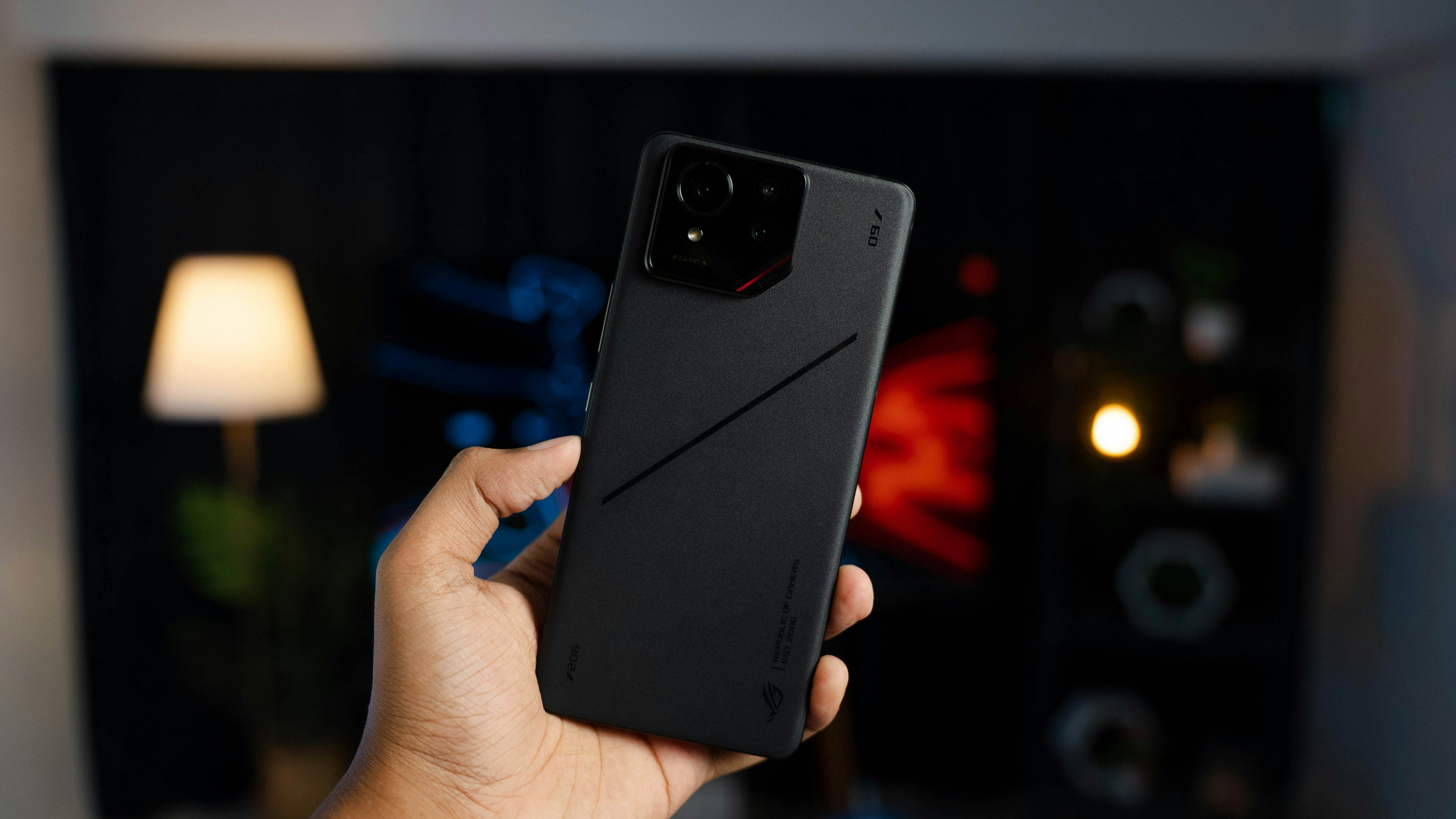 A person holding a black cell phone in their hand