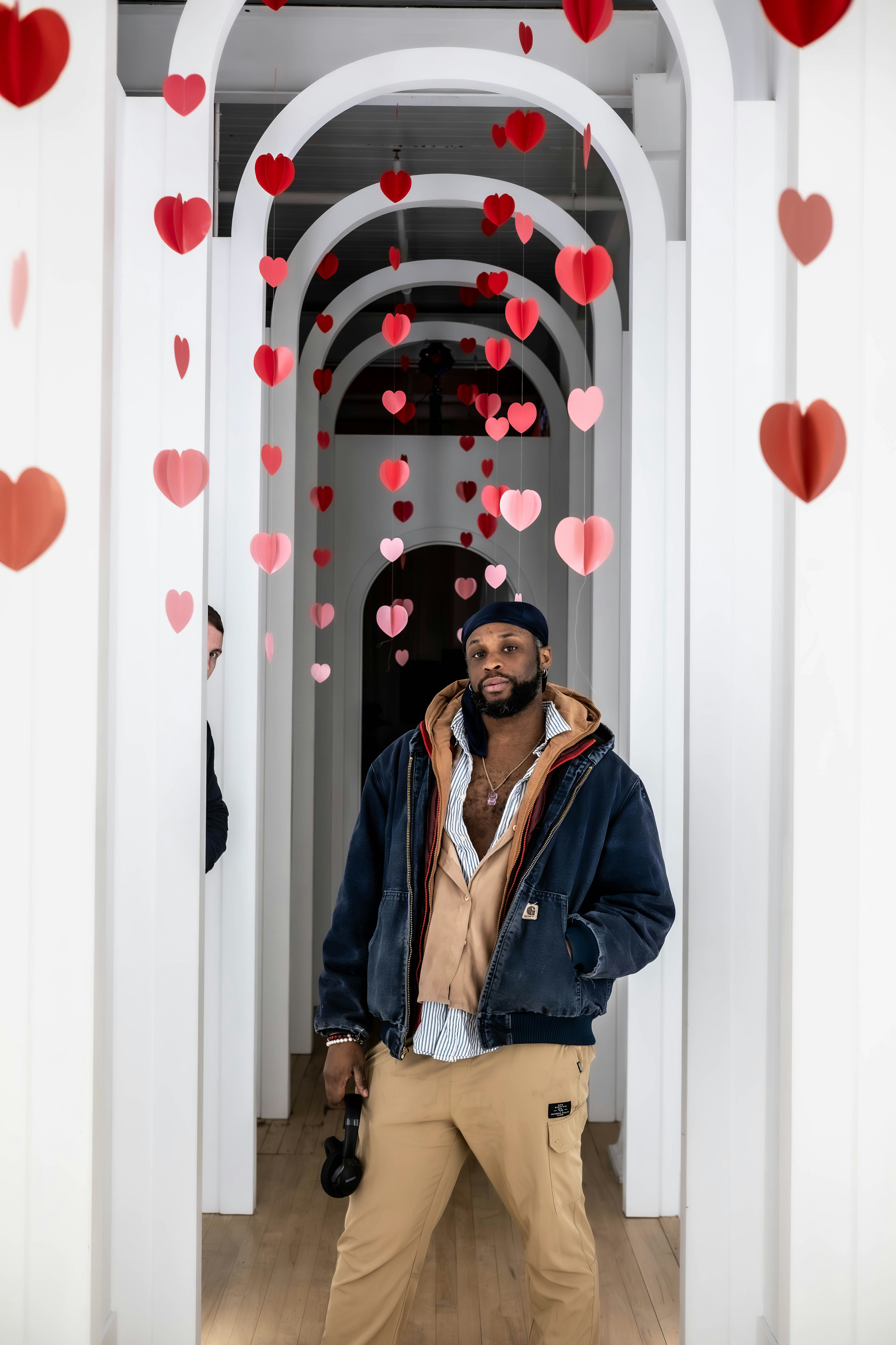 Ein Mann, der in einem Flur steht und dessen Herzen von der Decke hängen