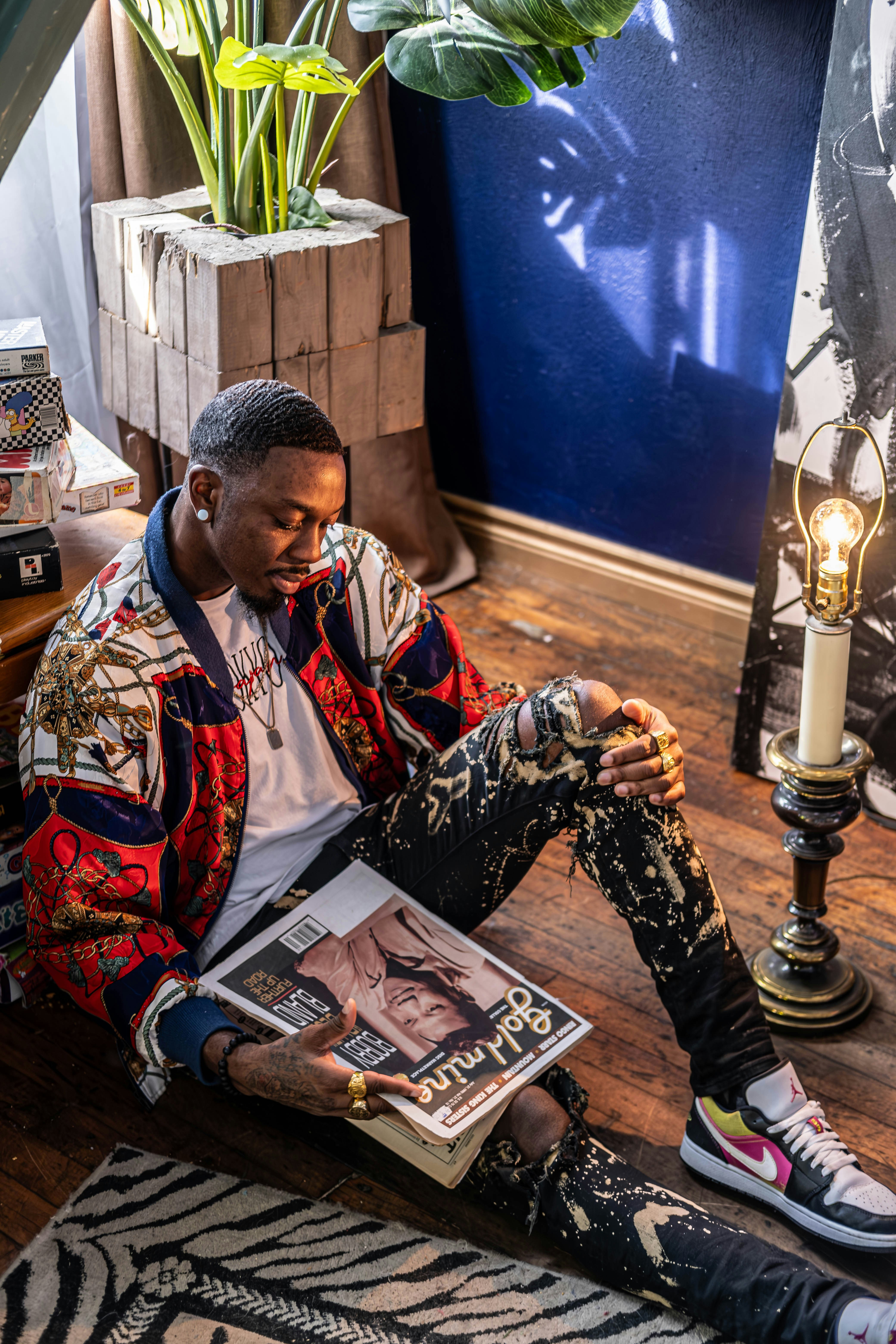 Ein Mann sitzt auf dem Boden und liest eine Zeitschrift